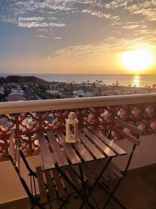 un banco sentado en la parte superior de un balcón con vistas a la puesta de sol en Margherita House Tenerife, Wonderful Ocean View, en Palm-mar