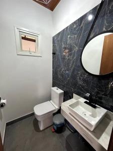 ein Badezimmer mit einem WC, einem Waschbecken und einem Spiegel in der Unterkunft Casa Meninas do Rio 01 in Lençóis