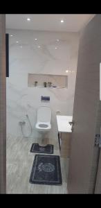 a bathroom with a white toilet and a sink at Sousse home in Hammam Sousse