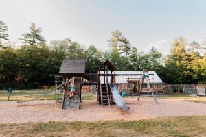 a playground with a slide and a play structure at Huttopia White Mountains in Albany