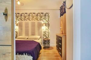 1 dormitorio con cama morada y ventana en Margherita House Tenerife, Wonderful Ocean View, en Palm-mar