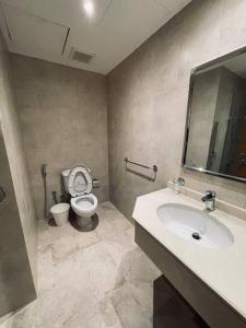 a bathroom with a toilet and a sink with a mirror at Luxurious, self-enter apartment in Jeddah