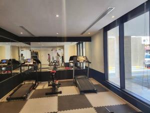 a gym with two treadying machines and a mirror at Luxurious, self-enter apartment in Jeddah