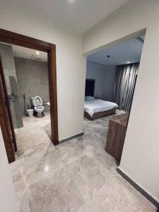 a bedroom with a bed and a bathroom with a toilet at Luxurious, self-enter apartment in Jeddah
