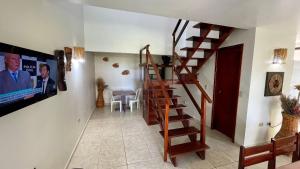 a staircase in a living room with a tv at Maragogi, LiaMara Accommodations in Maragogi