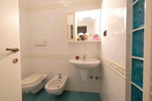 uma casa de banho branca com um lavatório e um WC em Lady - Pineto Vacanza em Pineto
