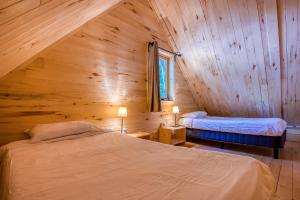 een slaapkamer met 2 bedden in een houten hut bij Huttopia White Mountains in Albany