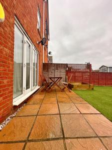 a patio with a picnic table next to a building at 4 Bed Town House with free parking in Eaton Socon