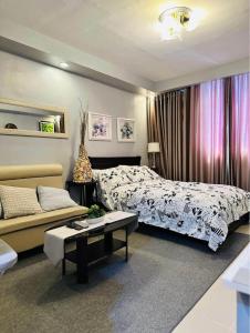 ein Schlafzimmer mit einem Bett und einem Sofa in der Unterkunft Yulee’s Comfortable Home Seakyung Village condo in Lapu Lapu City