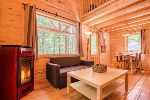 a living room with a couch and a fireplace in a log cabin at Huttopia White Mountains in Albany