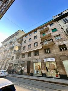 - un grand bâtiment en briques dans une rue de la ville dans l'établissement Casa Vanchiglia - Centro, à Turin