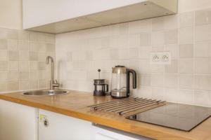 a kitchen with a stove top with a sink at Le calme et cosy avec parking gratuit in Lyon