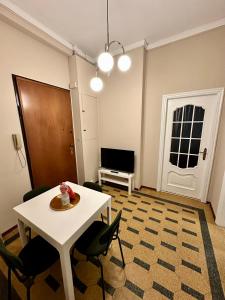 una stanza con tavolo e sedie bianchi e una porta di Casa Vanchiglia - Centro a Torino