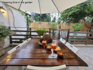 - une table en bois avec deux verres de vin sur la terrasse dans l'établissement Leoni63, à Palerme