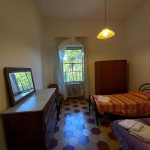 een slaapkamer met een bed, een dressoir en een raam bij L'Oasi - Locazione Turistica Pisa in Pisa