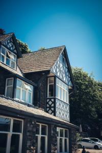 a stone house with white windows and a roof at Ravenstone Manor in Keswick