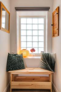 a wooden bench in a room with a window at Le chaleureux et cosy avec parking proche Lyon 