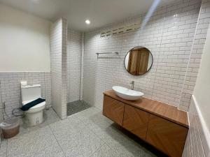 La salle de bains est pourvue d'un lavabo, de toilettes et d'un miroir. dans l'établissement Marina Resort Koh Phayam Ranong, à Ko Phayam