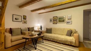 ein Wohnzimmer mit einem Sofa und einem Tisch in der Unterkunft Cottage by the river Valea Draganului in Poeni