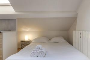 una camera da letto con un letto e asciugamani di Cosy pour un week-end ou déplacement pro a Lione
