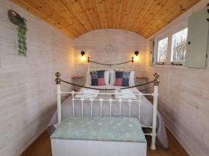 a bedroom with a bed in a small room at Aston - Shepherd Hut in Craven Arms
