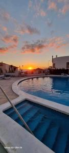 een groot zwembad met een zonsondergang op de achtergrond bij Beril D17 in Adeje