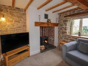 a living room with a fireplace and a flat screen tv at Wayside House in Craven Arms