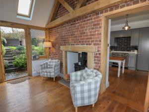 a living room with a brick wall and two chairs at Wayside House in Craven Arms