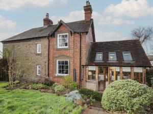 an old brick house with windows and a yard at Wayside House in Craven Arms