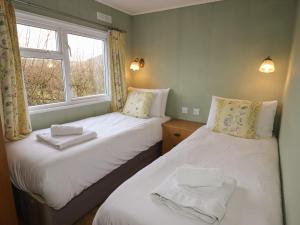 2 aparte bedden in een kamer met een raam bij Wayside Lodge in Craven Arms