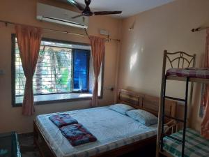 a bedroom with a bunk bed and a window at Govindaashram in Bhogwe