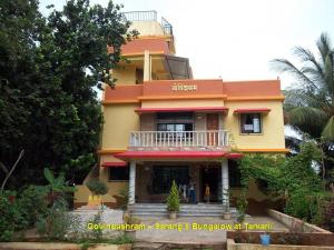 un edificio giallo e arancione con balcone di Govindaashram a Bhogwe