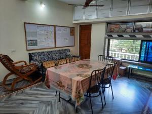 a room with a table and chairs and a couch at Govindaashram in Bhogwe
