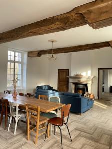 un soggiorno con tavolo in legno e divano blu di Domaine de Bontemps 