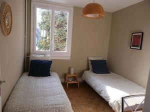 2 camas en una habitación con ventana en Appartement de designer, Cosy Lumineux, 3 chambres, en Le Kremlin-Bicêtre