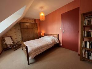 a bedroom with a bed and a book shelf at 350 - Charmante maison dans le bourg de Plévenon à 1 kilomètre des plages in Plévenon