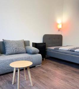 ein Wohnzimmer mit einem Sofa und einem Tisch in der Unterkunft 2-Schlafzimmer-Wohnung mit Parkplatz-Balkon-Küche- Garten, Nahe DUS Airport, Messe in Duisburg