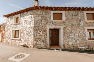 a stone building with a door in front of it at Casa Rural El Cañico in Otero de Bodas
