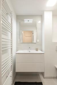 NEW apartment. UE - City center في بروكسل: حمام أبيض مع حوض ومرآة