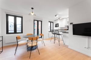 NEW apartment. UE - City center في بروكسل: مطبخ وغرفة معيشة مع طاولة وكراسي