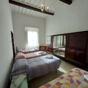 een slaapkamer met 2 bedden en een spiegel bij L'Oasi - Locazione Turistica Pisa in Pisa