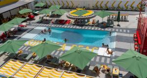 una vista sul tetto di una piscina con ombrelloni verdi di Ryans Lolas - Adults Only a Baia di Sant'Antoni