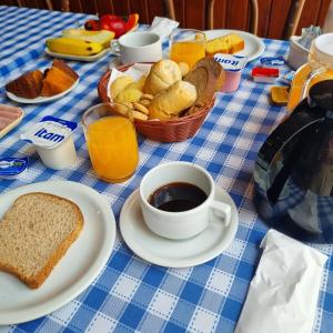einen Tisch mit einer Tasse Kaffee und einem Korb Brot in der Unterkunft Hotel Barroco Mineiro in Ouro Preto
