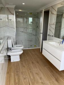 een badkamer met een toilet, een wastafel en een douche bij Seculo Hotel in Porto