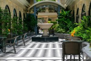 une cour avec des chaises et une fontaine dans un bâtiment dans l'établissement The Sukosol Hotel, à Bangkok