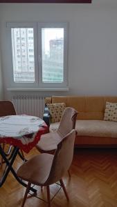 sala de estar con sofá, mesa y sillas en ALVOBAR Apartment en Skopie