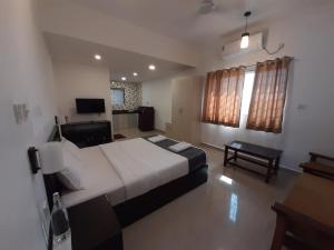 a bedroom with a large white bed and a television at Hotel RSA Residency in Pernem