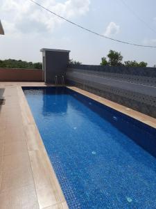 a swimming pool on the side of a building at Hotel RSA Residency in Pernem