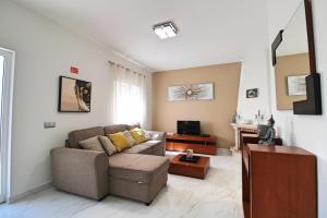 ein Wohnzimmer mit Sofa und Fernseher in der Unterkunft Villa Ribeiro By Keys to Algarve in Armação de Pêra