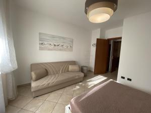 ein Wohnzimmer mit einem Sofa und einem Bett in der Unterkunft AGOS in San Vincenzo